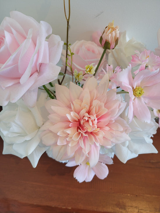 Bouquet of pink and white flowers against a wooden bench