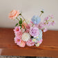 Bouquet of colorful flowers on a wooden surface with a neutral background