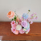 Bouquet of colorful flowers on a wooden surface with a neutral background