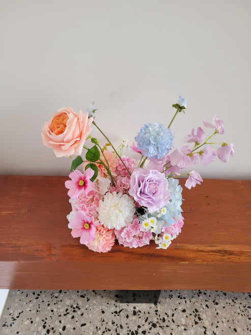 Bouquet of colorful flowers on a wooden surface with a neutral background