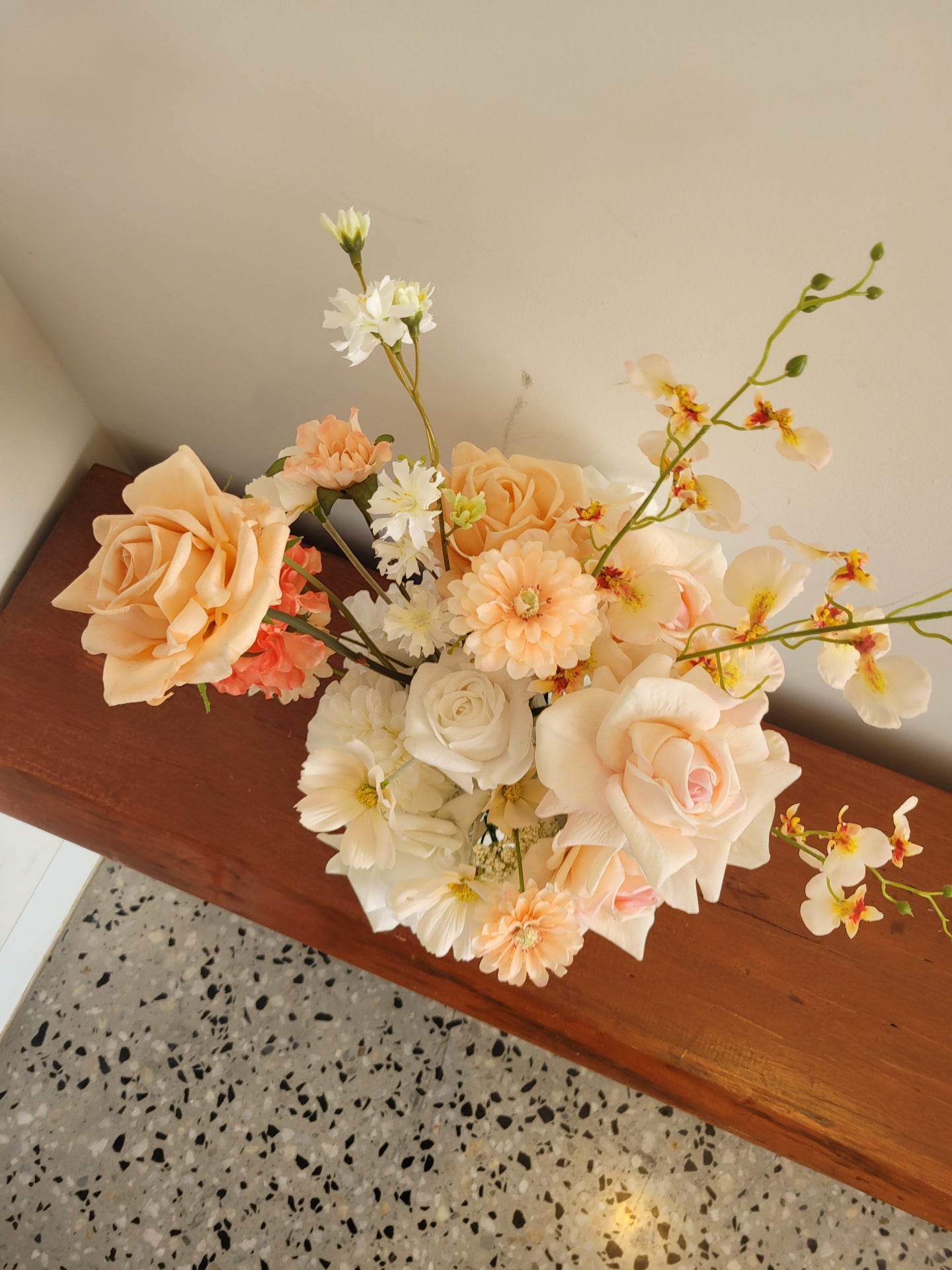 Bouquet of flowers on a wooden surface with a speckled countertop in the background