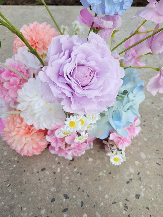 Pastel-colored flowers on a concrete surface