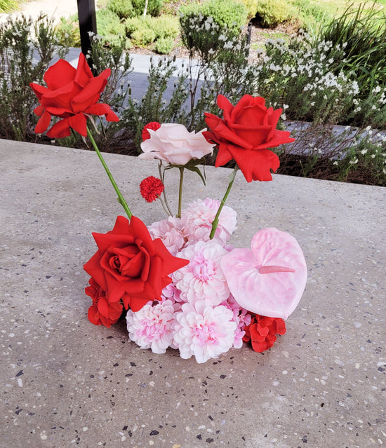 Cloud of red and pink flowers on a concrete surface with a natural background