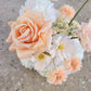 Bouquet of peach and white flowers on a concrete surface