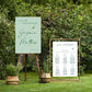Two wedding signs on stands with greenery in the background