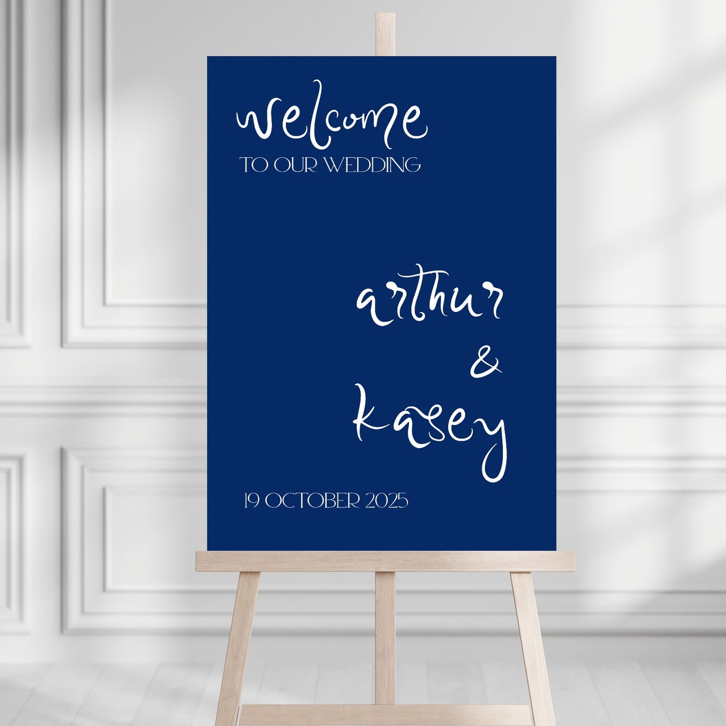 Wedding welcome sign on an easel with a blue background and white text.