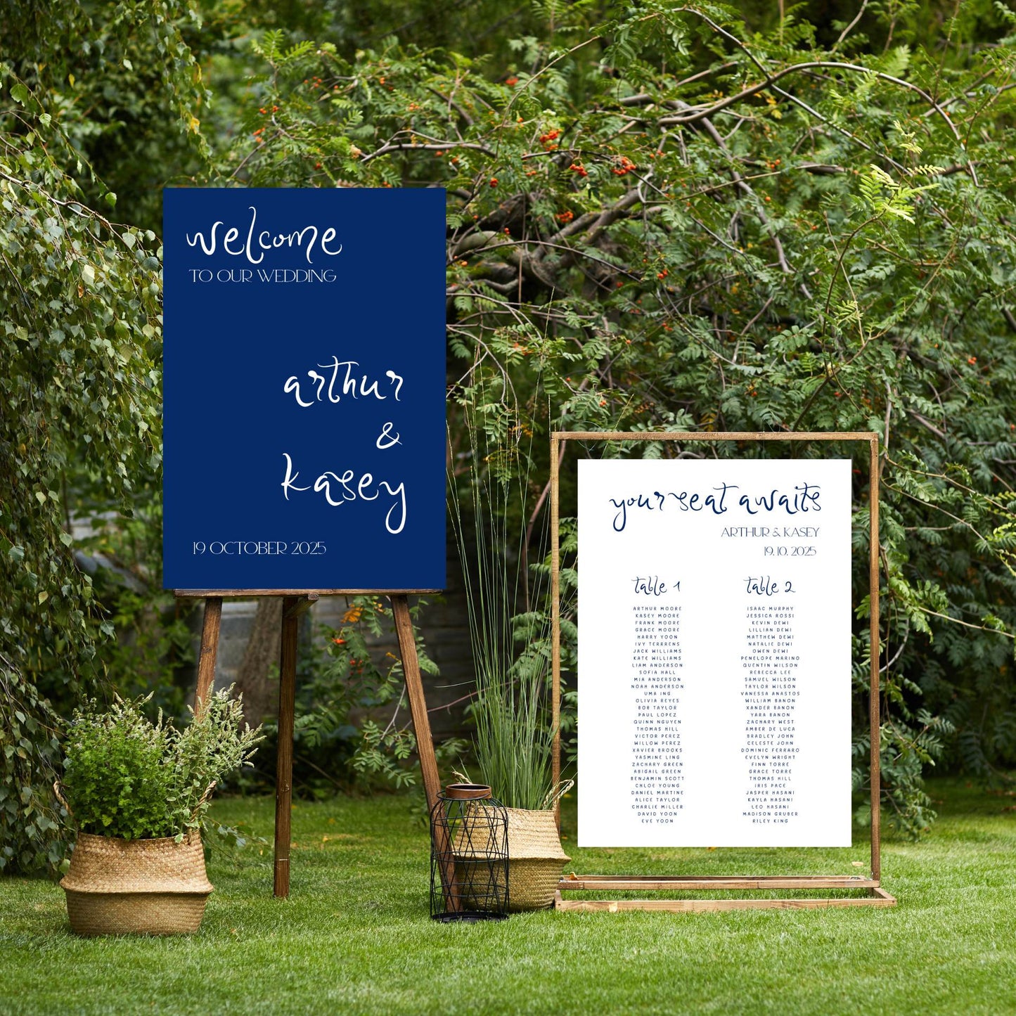 Wedding welcome sign and seating chart in an outdoor setting with greenery.