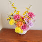 Bright flower arrangement with pink, orange, yellow and lilac blooms