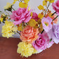 Close up of bright flowers, especially pink and orange roses
