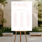 Seating chart on an easel outdoors with trees and a building in the background