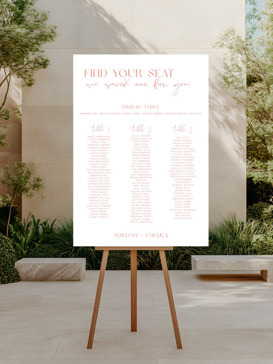 Seating chart on an easel outdoors with trees and a building in the background