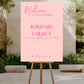 Pink welcome sign for a wedding on an easel outdoors