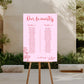 Pink table seating chart on an easel outdoors