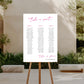 Seating chart on an easel outdoors with garden and building in the background