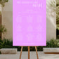 Purple seating chart poster on an easel outdoors