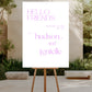 White sign with 'Hello Friends' and names on a wooden stand outdoors.
