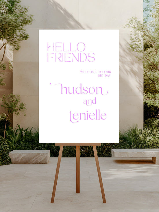 White sign with 'Hello Friends' and names on a wooden stand outdoors.