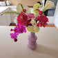 Flower arrangement is a purple vase featuring a calla lily and orchid