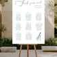 Seating chart on an easel outdoors with a garden background