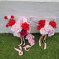 Two wedding bouquets with red and pink flowers on a grassy surface.
