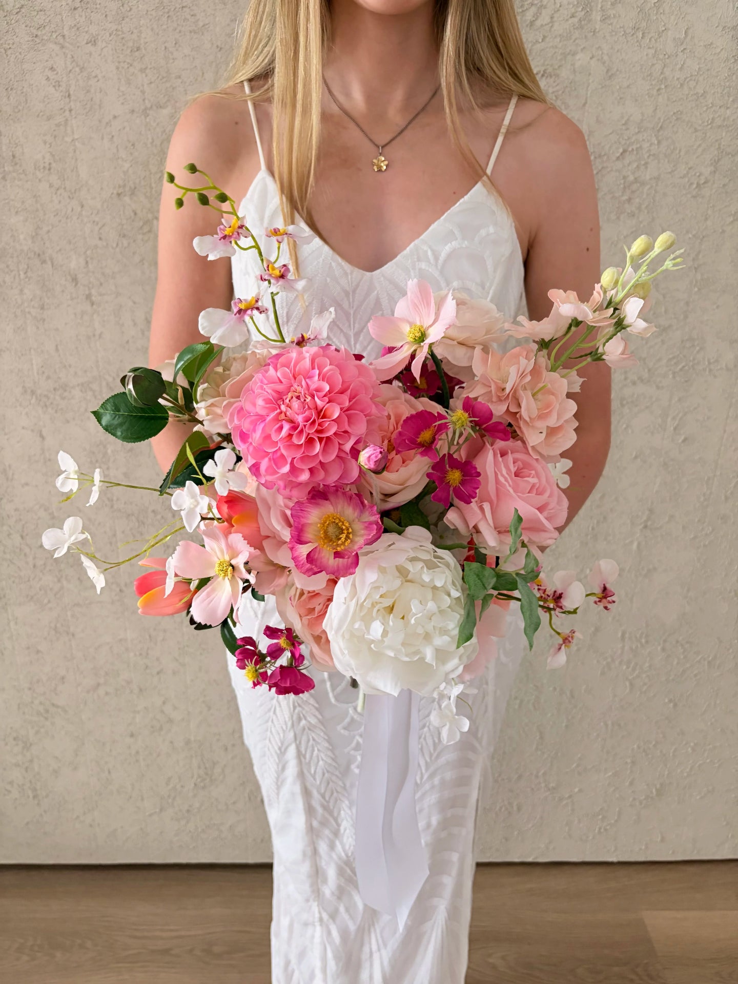 Woman holding a bouquet of spring flowers against a neutral background