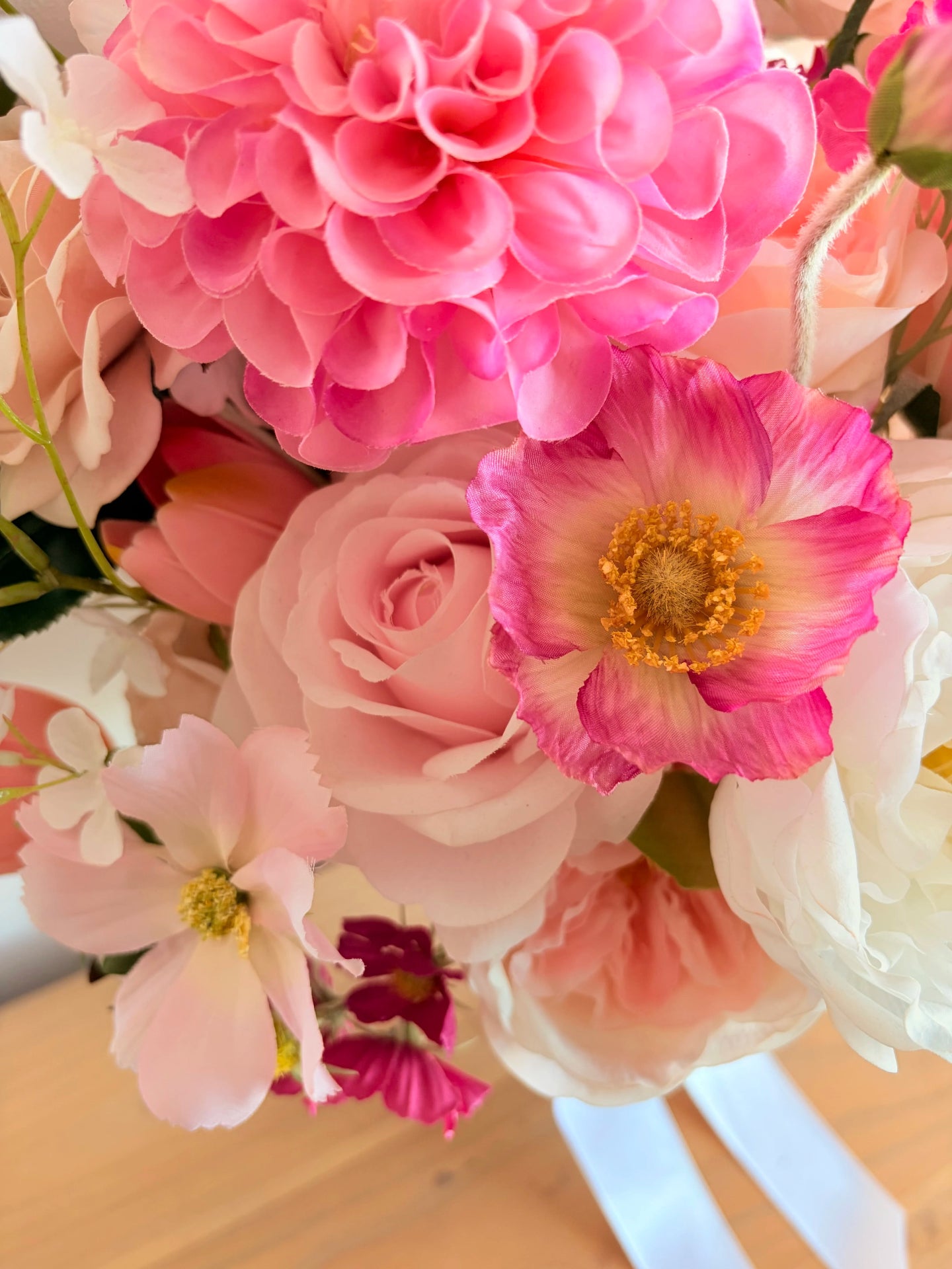 Close up of an artificial dahlia, poppy and rose in a pink palette