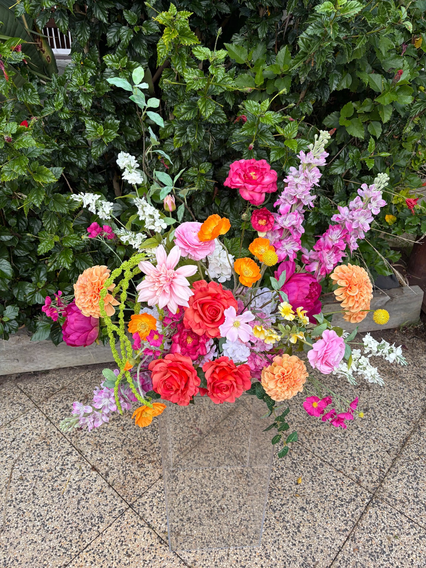 Whimsical artificial wedding flower arrangement with pink and orange flowers