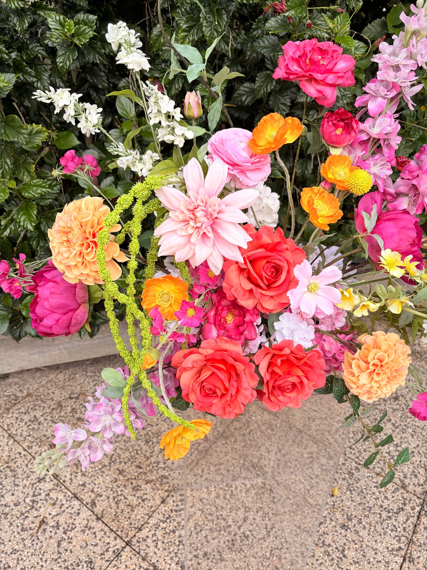 Close up of whimsical pink and orange faux wedding flowers with green amaranthus