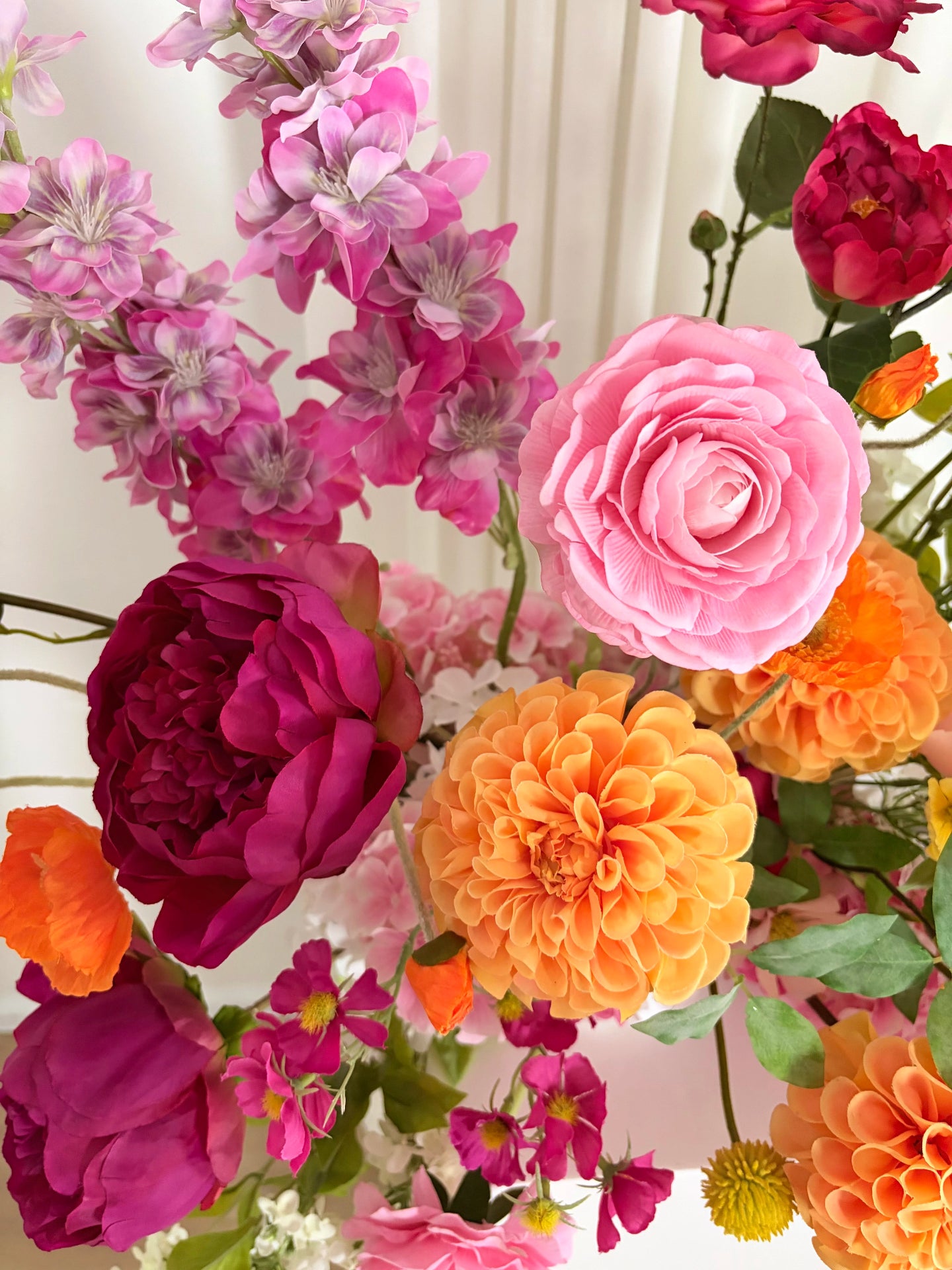 Close up of real touch artificial flowers in pink and orange tones