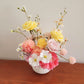 A cheerful arrangement of yellow, pink and white artificial flowers