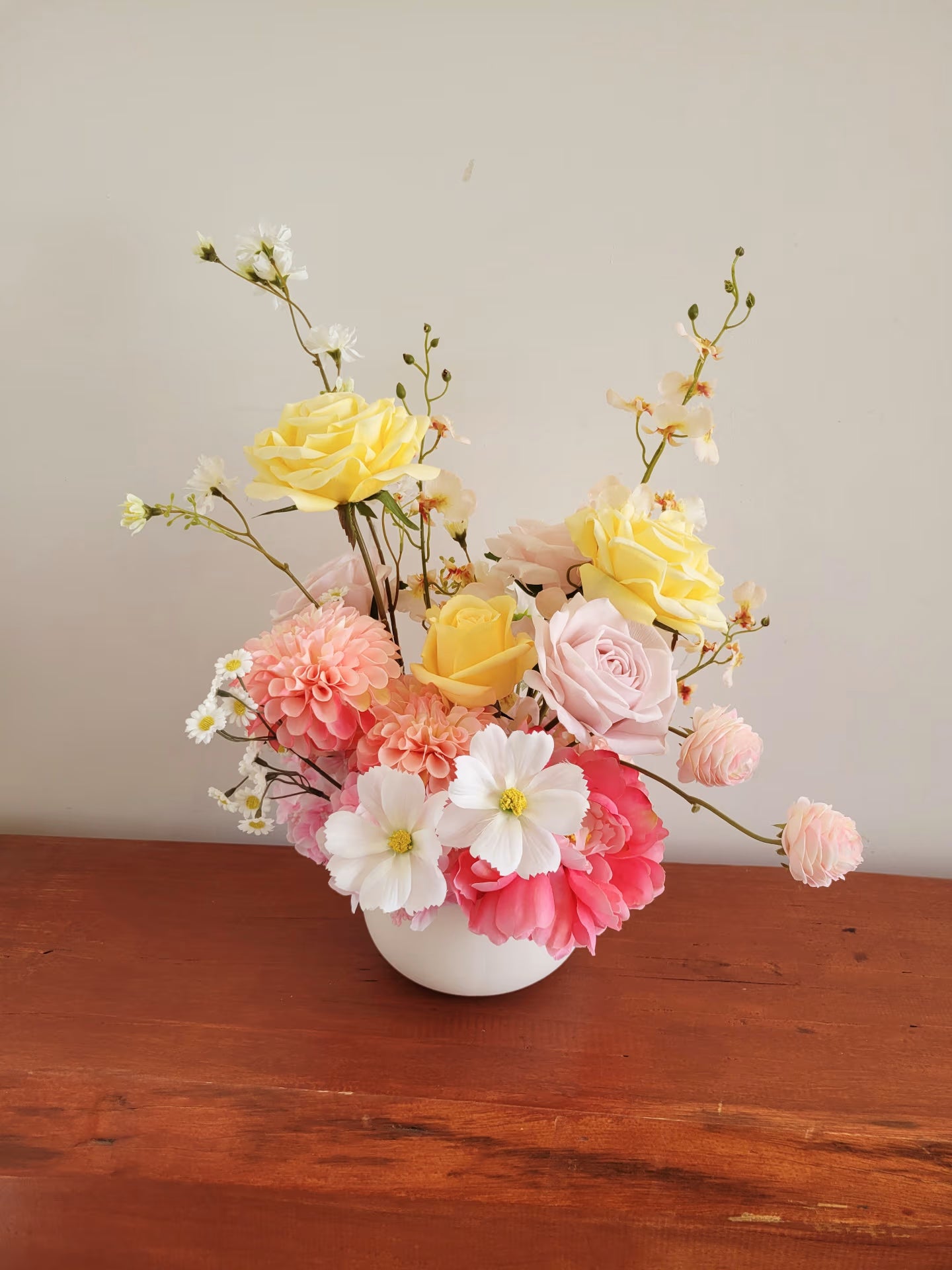 A cheerful arrangement of yellow, pink and white artificial flowers