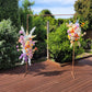 Floral arches on a wooden deck with greenery in the background
