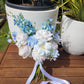 blue and white wedding bouquet leaning against a large white port