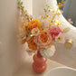 Floral arrangement in a pink vase on a bathroom counter