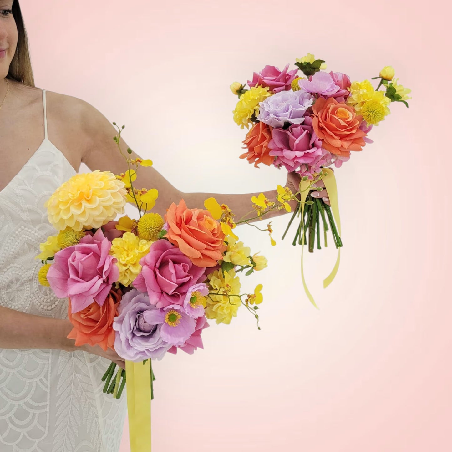 Woman holding two colorful flower bouquets against a pink background