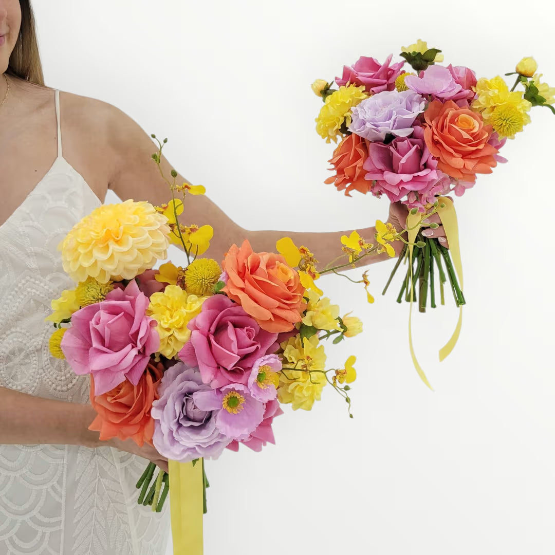 Woman holding two colorful flower bouquets against a white background