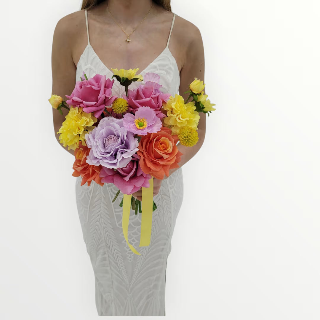 Woman holding a colorful bridal bouquet of flowers against a white background