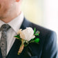 Close up of groom wearing a white rose buttonhole
