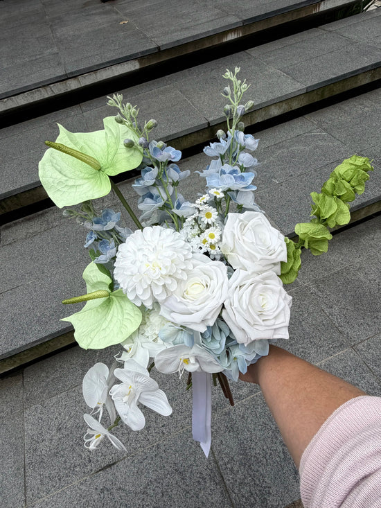 Bouquet of flowers held by a person on stone steps
