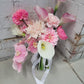 Wedding bouquet of pink and white flowers with a white ribbon on a light surface.