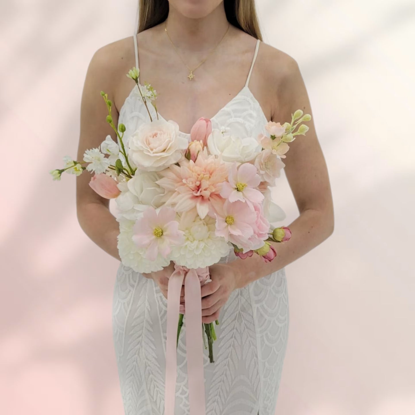Lady holding a bridal bouquet that is soft pink and white