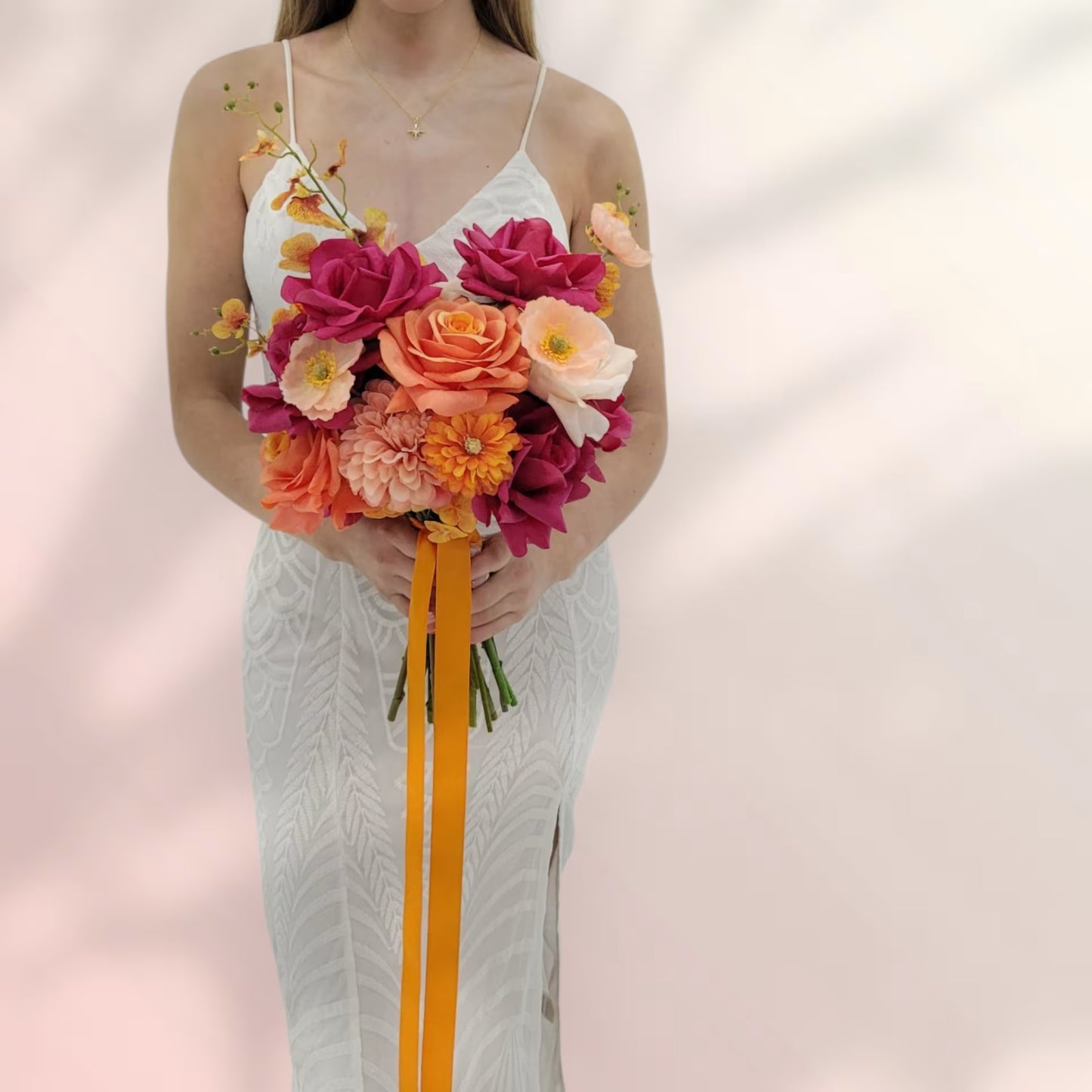 Woman holding a bouquet of flowers against a soft pink background