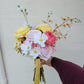 Bouquet of flowers held by a person against a plain background