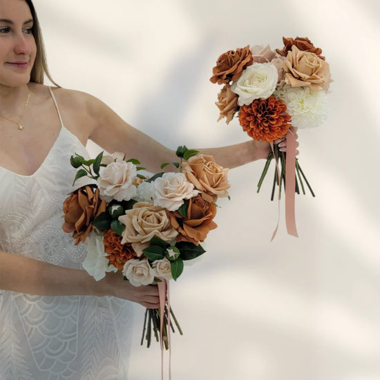 Woman holding two floral bouquets with a plain background